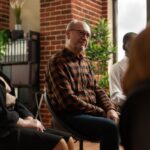 People talking to therapist at aa group therapy meeting, sharing addiction problems