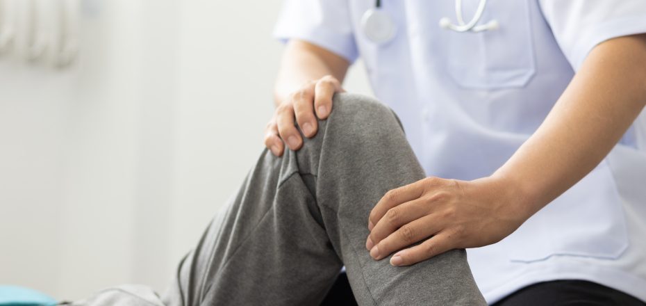 The doctor performs physical therapy on the patient's knee in the medical examination room.